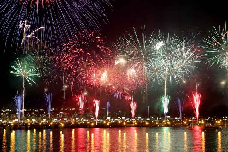 Buntes Hanabi-Feuerwerk ueber dem Wasser als Bild fuer die Japan Feuerwerk-Reise